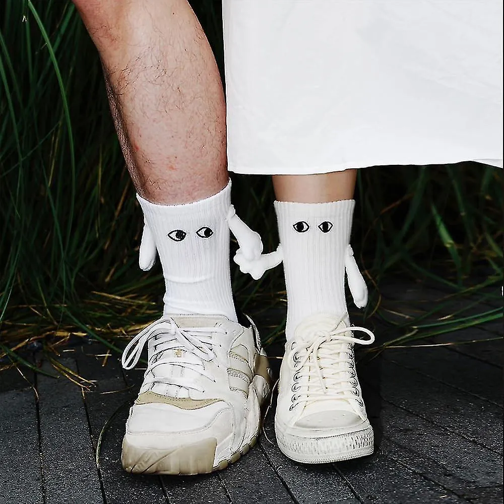 Calcetines magnéticos de mano que sostienen nuevos, calcetines de mano a mano, pareja que sostiene calcetines de manos