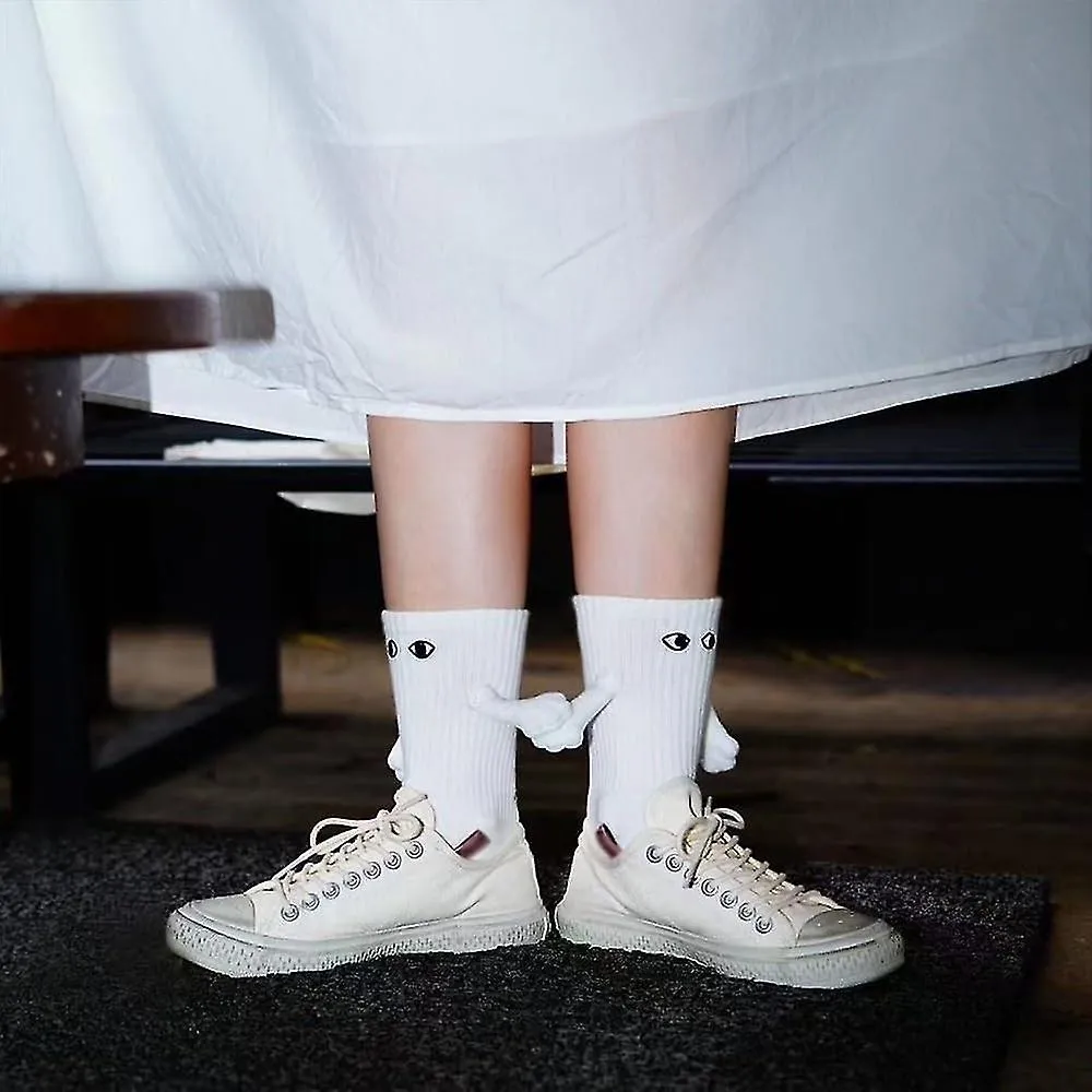 Calcetines magnéticos de mano que sostienen nuevos, calcetines de mano a mano, pareja que sostiene calcetines de manos